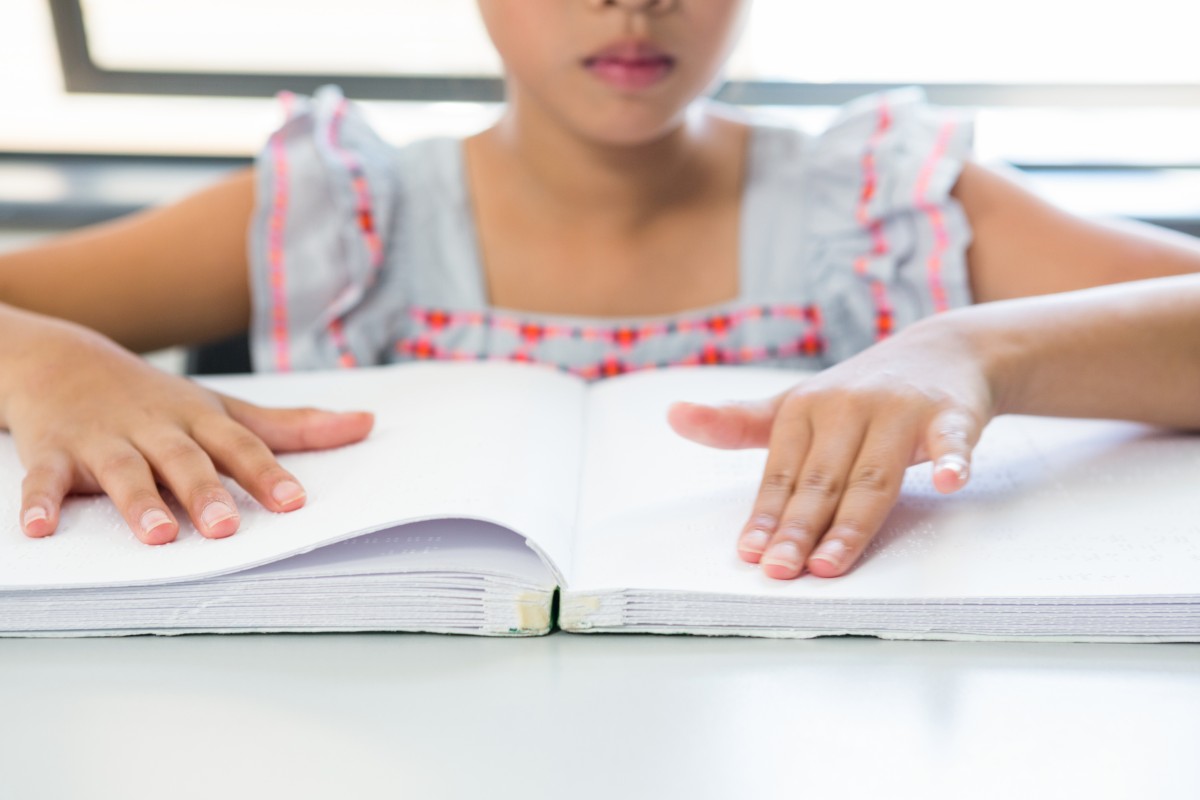 Blind child reading braille book. Source: Shutterstock