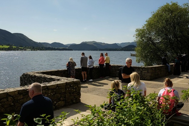 People look out over Ullswater in the summer sunshine in Pooley Bridge in the Lake District. Source: Oli Scarff/