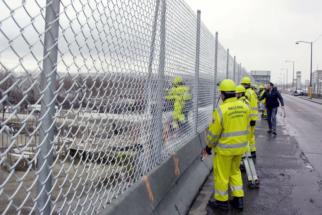 Construction workers continue erecting a security fence for the Summit of the Americas 12 April 2001 in Quebec City. The fence is over 3km (1.86 miles) long and will be used to keep protesters at a distance during next week’s summit.   PHOTO/Marcos TOWNSEND (Photo by MARCOS TOWNSEND / )