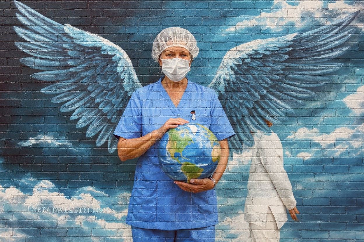 A woman looks at a mural of a health worker with wings holding a globe on International Nurses Day in Melbourne on May 12, 2020. As frontline hospital staff are constantly facing the risks from the COVID-19 coronavirus outbreak, the world is marking International Nurses Day, celebrated around the world every May 12, the anniversary of Florence Nightingale’s birth. (Photo by William WEST / )