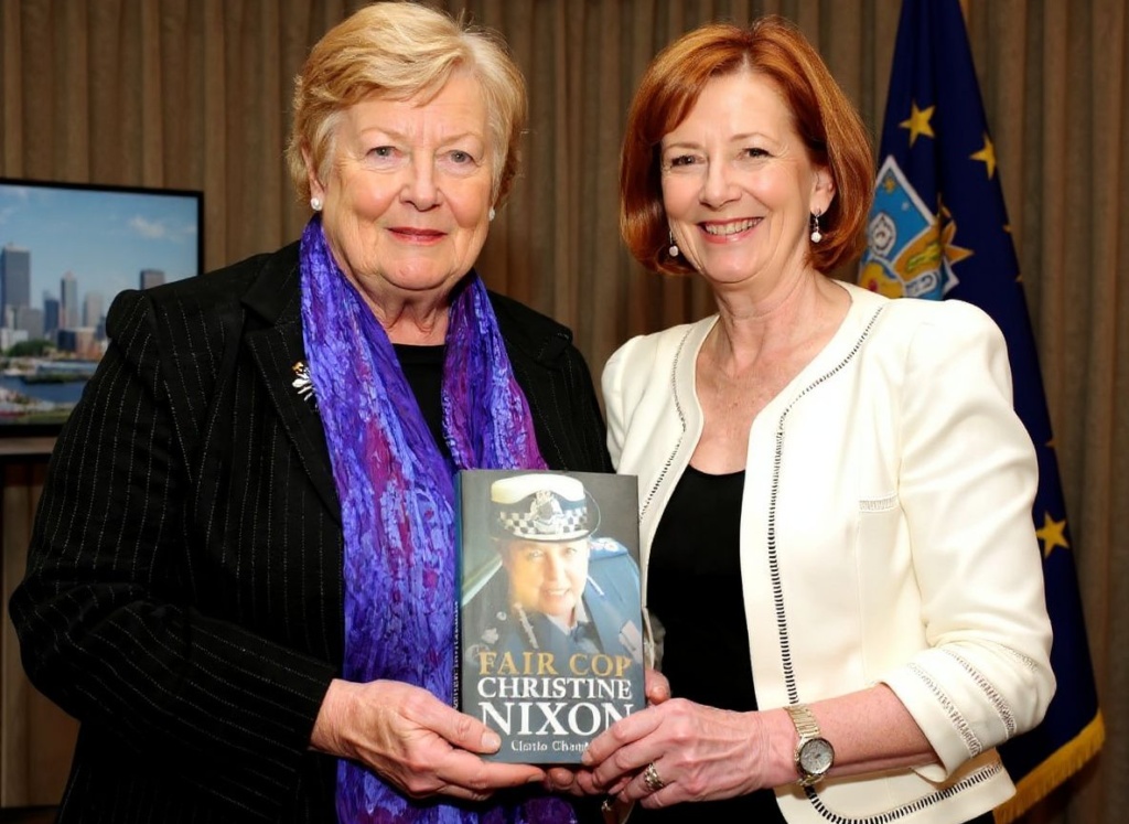 Australian Prime Minister Julia Gillard (R) poses for a photo after launching the book ‘Fair Cop’ by former Victoria state police commissioner Christine Nixon (L) in Melbourne on August 3, 2011. In the book, Nixon claims she was the target of a News Limited campaign to oust her, fuelled by detractors in the police force.  Nixon faced a remarkable series of challenges during her time at the top, including the September 11 terrorist attacks, Melbourne’s gangland wars and the deadly “Black Saturday” bushfires in which she was heavily crictised by Rupert Murdoch’s News Ltd, for having a pub meal that evening.   PHOTO / William WEST (Photo by WILLIAM WEST / )