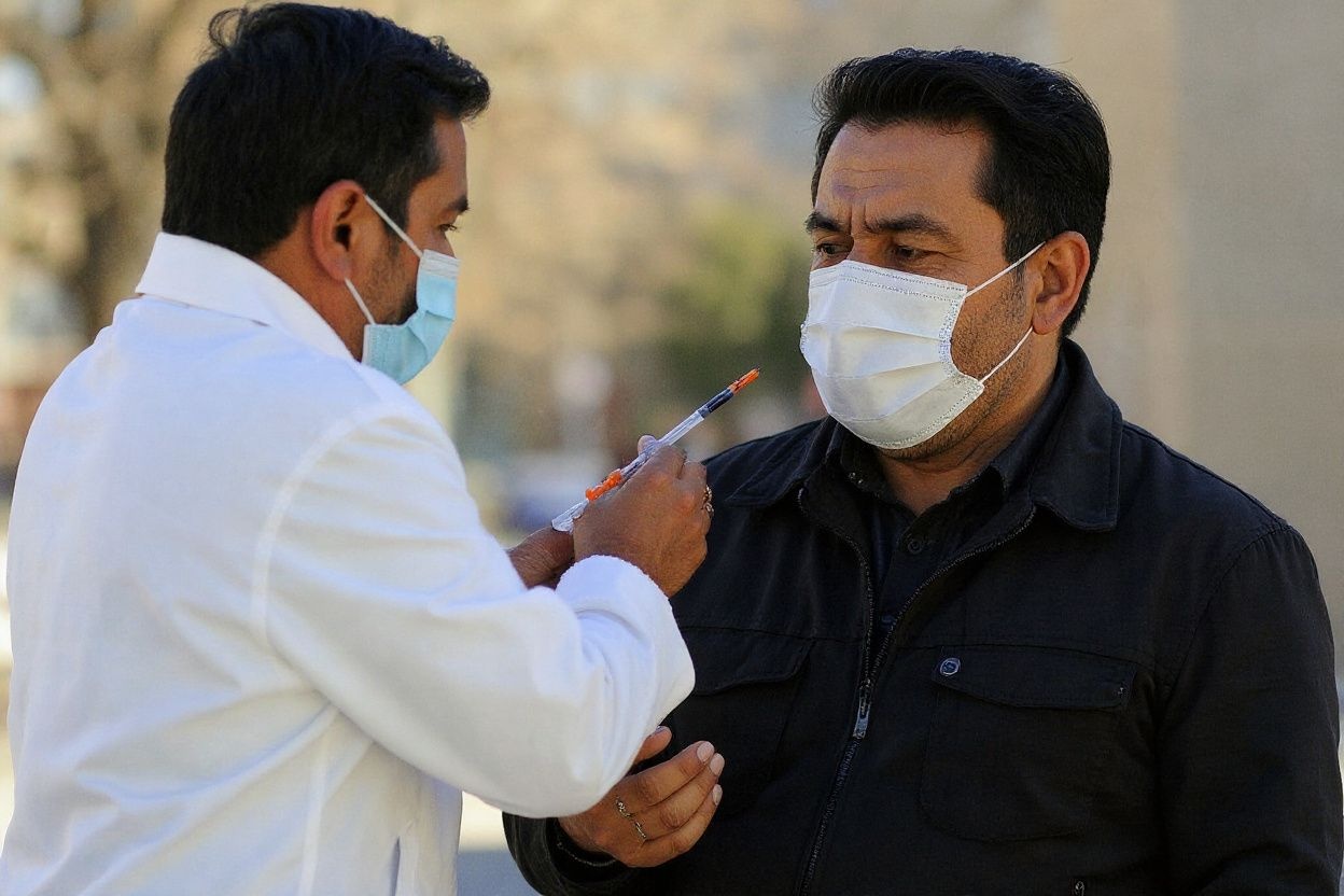 A man receives the first dose of the Sputnik V vaccine against COVID-19 at the Bolivia square in La Paz, on January 6, 2022. – COVID-19 cases reached a record 10,263 people on Wednesday since the pandemic began, while the city of Santa Cruz, the epicenter of infections, fears a state of emergency. (Photo by JORGE BERNAL / )