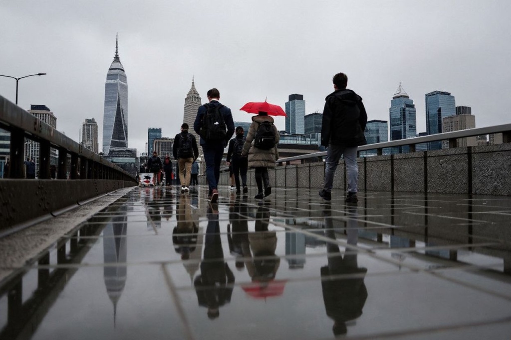 Pedestrians walk over the London Bridge with the City financial district on the background, in London, on November 2, 2023. (Photo by HENRY NICHOLLS / )