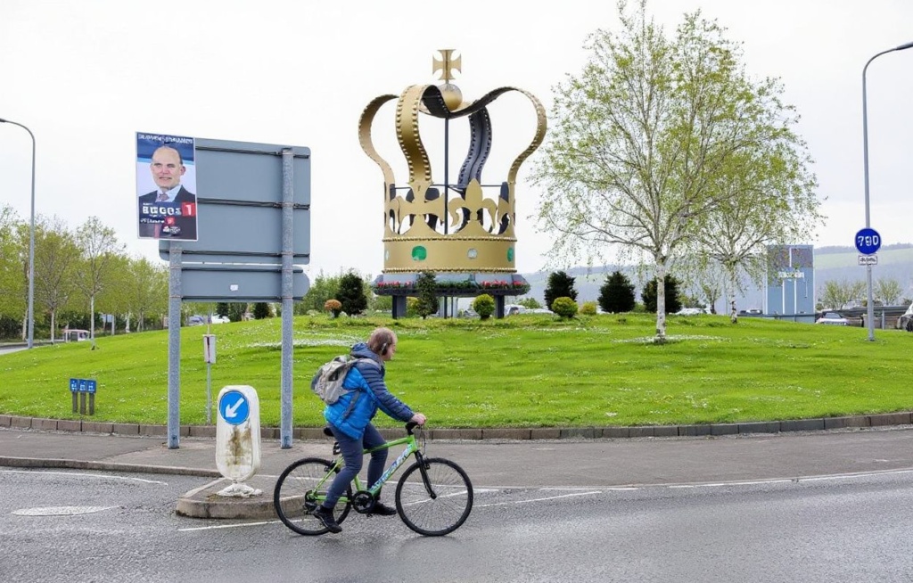 A cyclist passes Larne roundabout Jubilee crown in Larne, north of Belfast in Northern Ireland on May 5, 2023, in the build-up to the coronation weekend. (Photo by Paul Faith / )