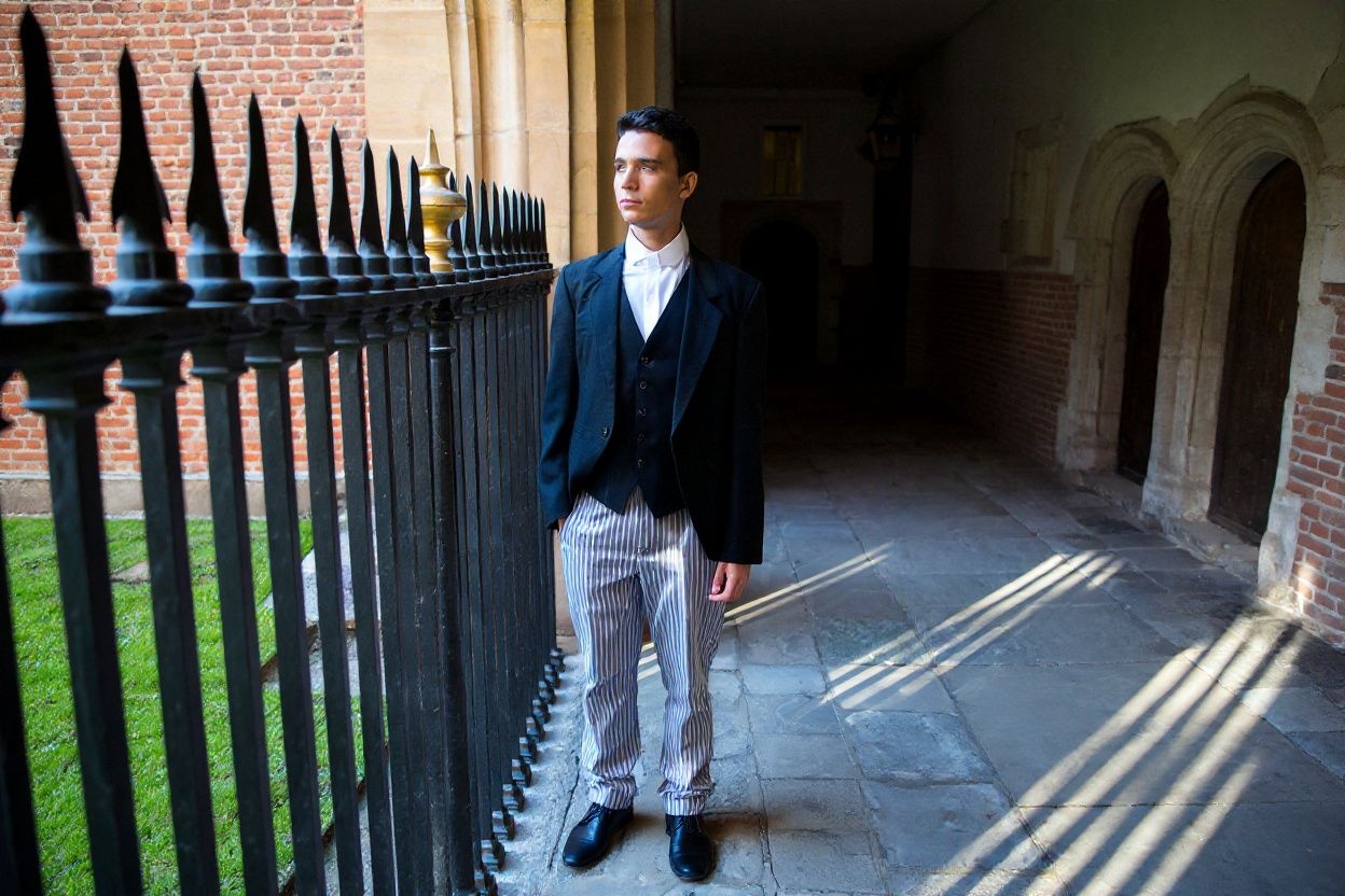 Eton College’s uniforms consists of a waistcoat, white tunic shirt, and stripped trousers. Source: