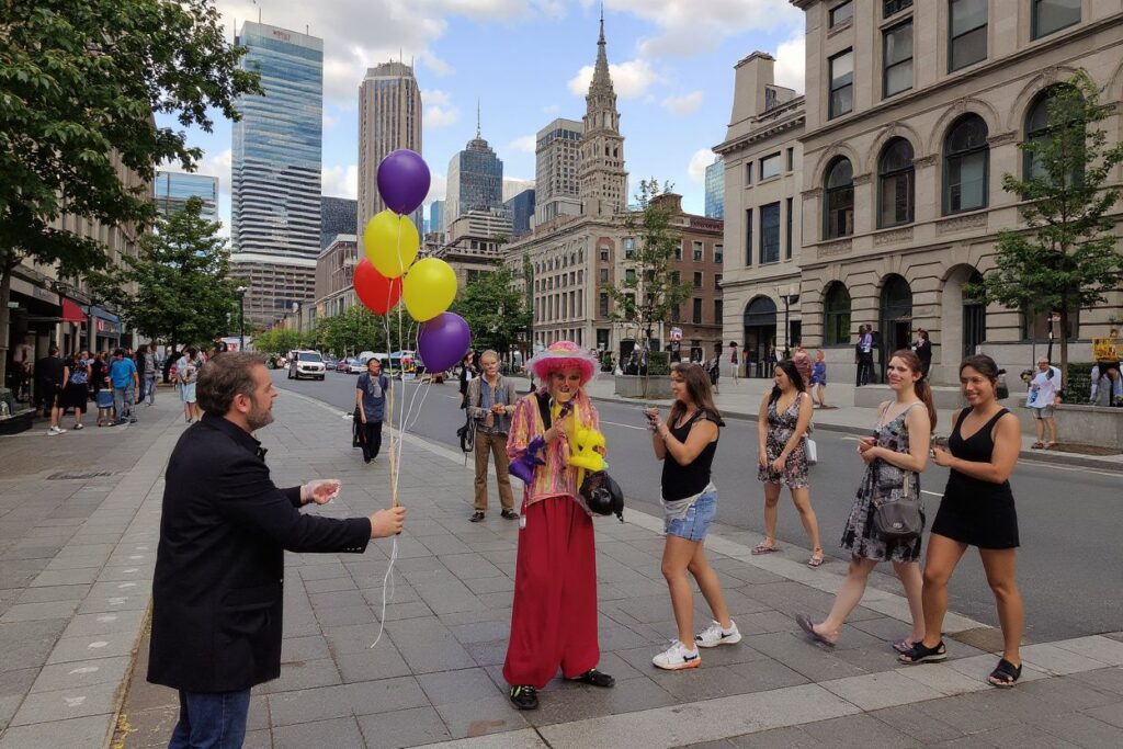 A street artist makes balloons to people at Jacques Cartier square in Old Montreal, Quebec. Source: Daniel Slim/