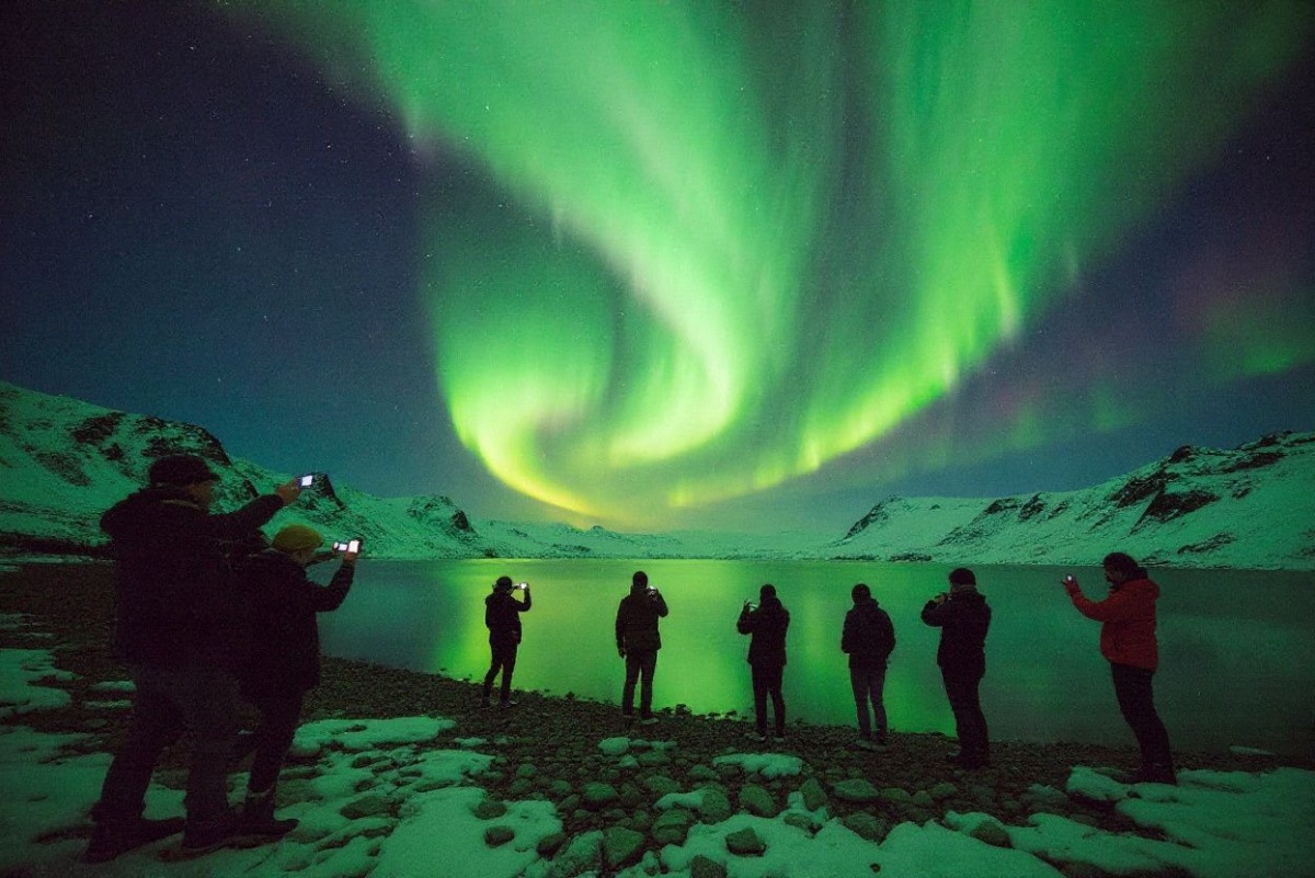 Tourists photograph the Northern Lights at lake Thingvellir, Iceland on January 13, 2016. An island of ice and lava battered by the Arctic winds, Iceland’s dramatic and pristine landscape is attracting a growing number of tourists, not all of whom are respectful of the fragile ecosystem. (Photo by Halldor KOLBEINS / )
