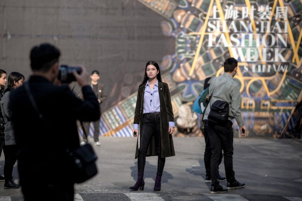 This picture taken on March 30, 2018 shows photography enthusiasts taking pictures of an arriving attendee at the Shanghai Fashion Week in Shanghai. (Photo by Johannes EISELE / )