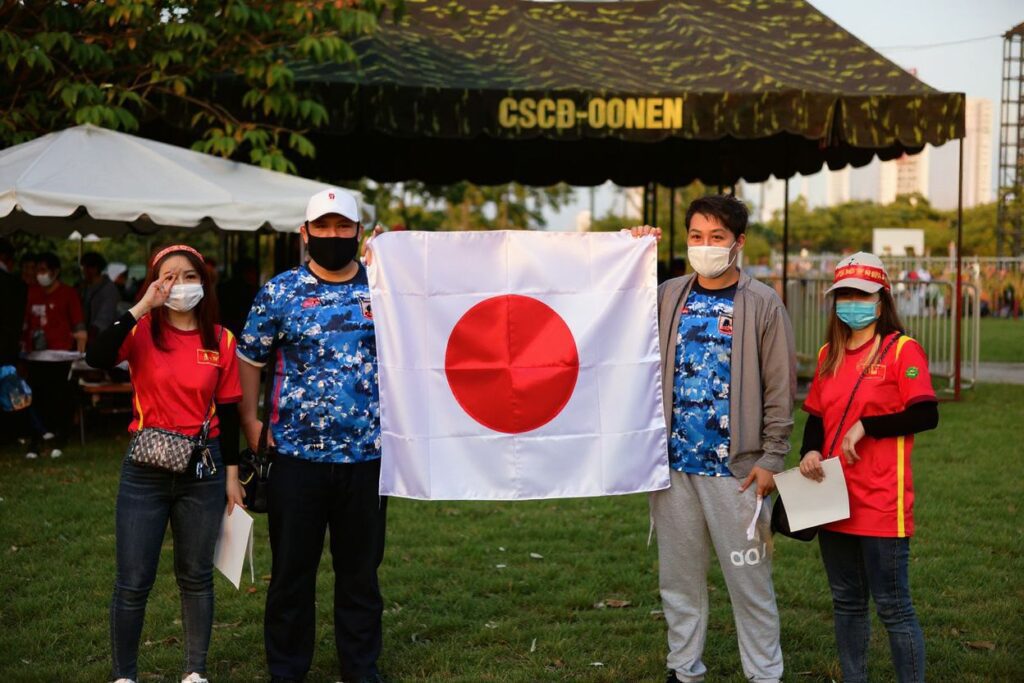 Japanese fans hold up their national flag ahead of the FIFA World Cup Qatar 2022 qualifying round Group B football match between Vietnam and Japan at the My Dinh National Stadium in Hanoi on November 11, 2021. (Photo by Nhac NGUYEN / )