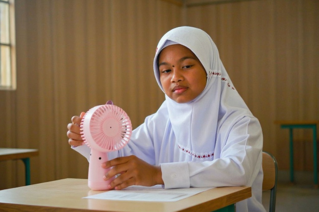 (FILES) A primary school student uses a portable fan to keep cool in a classroom during hot weather in Banda Aceh on May 15, 2023. Scientists say global warming is exacerbating adverse weather, with many countries experiencing deadly heatwaves and temperatures hitting records across Southeast and South Asia in recent weeks. 
In May, the United Nations warned it is near-certain that 2023-2027 will be the warmest five-year period ever recorded, as greenhouse gasses and El Nino combine to send temperatures soaring.
There is a two-thirds chance that at least one of the next five years will see global temperatures exceed the more ambitious target set out in the Paris accords on limiting climate change, the UN’s World Meteorological Organization (WMO) said. (Photo by Chaideer MAHYUDDIN / )