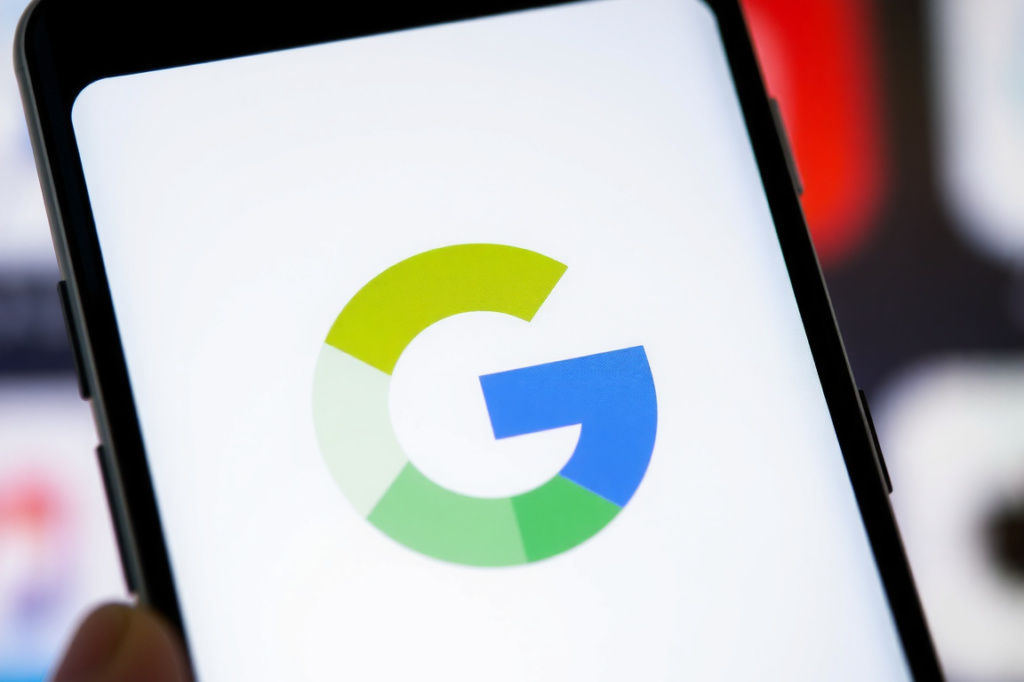 (FILES) This illustration photograph taken on December 22, 2023, shows the logo of US multinational technology and Internet-related services company Google displayed on a smartphone’s screen, in Frankfurt am Main, western Germany. Google on February 8, 2024 rebranded its ChatGPT-style chatbot to Gemini, giving it unprecedented prominence on its products, as the tech titan’s AI race with Microsoft heats up. (Photo by Kirill KUDRYAVTSEV / ), shot on Sony A7R IV, 85mm f/1.4 lens, RAW photograph, unedited, candid moment, natural lighting, photojournalistic style | NEGATIVE: AI generated, artificial, computer generated, digital art, 3d render