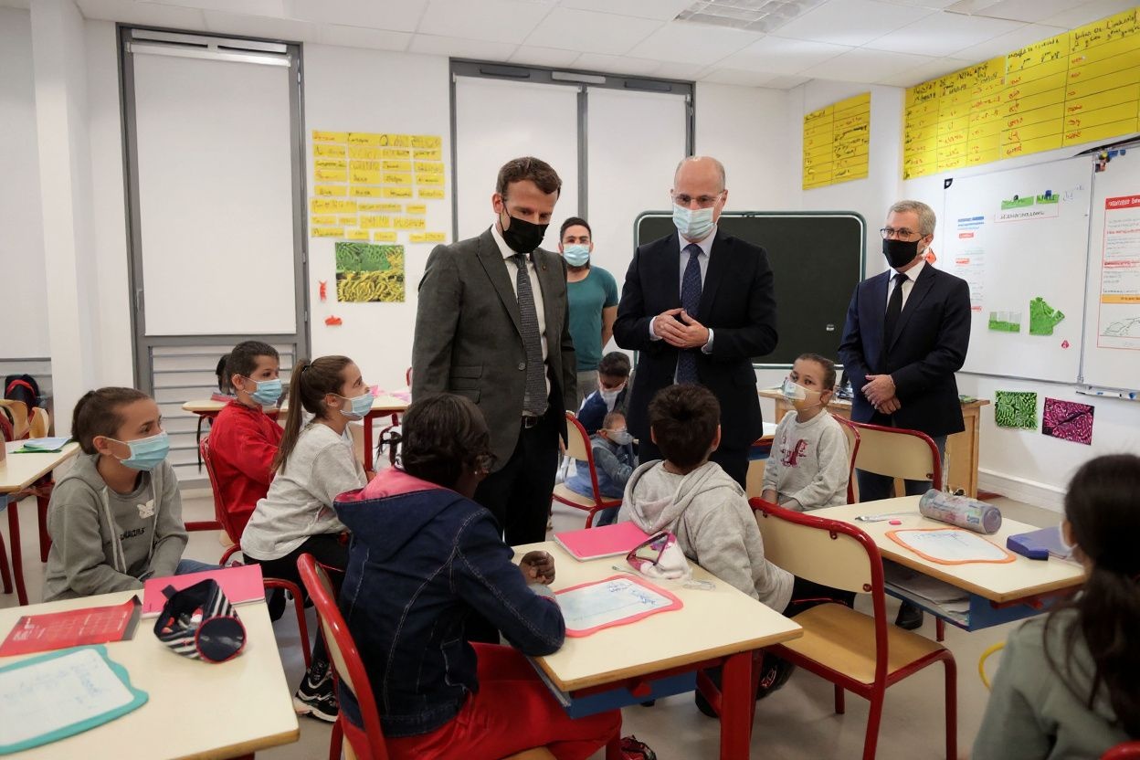 French President Emmanuel Macron  and French Education, Youth and Sports Minister Jean-Michel Blanquer  speak with pupils during a visit at a primary school in Melun in France. Source: Thibault Camus/