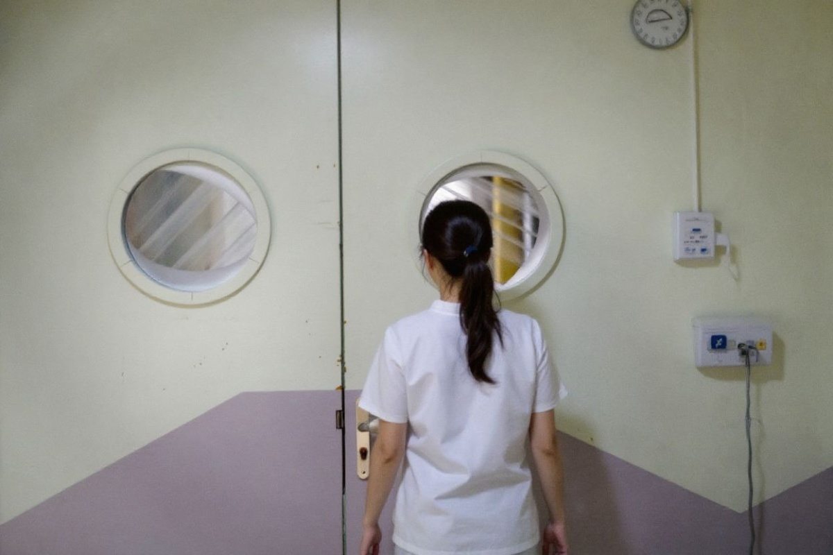 A nurse looks through a porthole in a hospital ward in Strasbourg, eastern France, on February 1, 2025. (Photo by ELSA RANCEL / )
