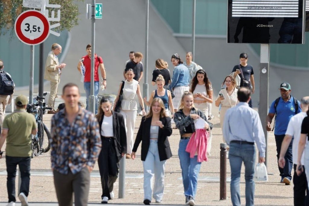 People walk across the esplanade at La Defense, near Paris on September 14, 2023. (Photo by Ludovic MARIN / )