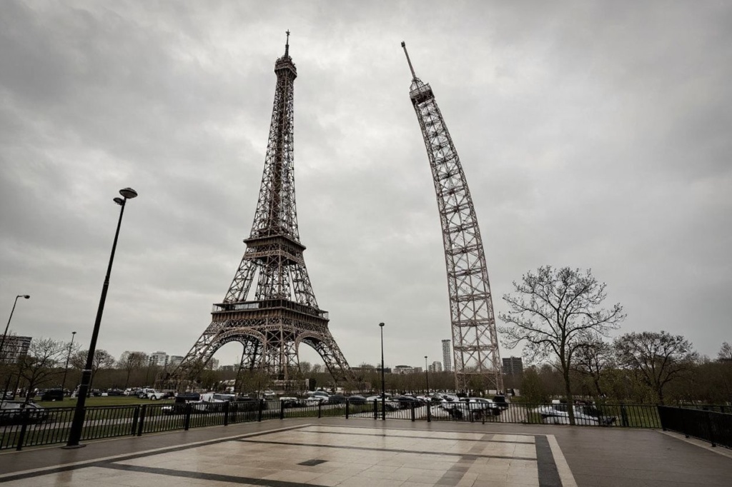 A photograph taken on April 1, 2023 shows a repliqua (L) of the Eiffel Tower, set near the original one in Paris. – “Eiffela”, a replica of the famous Parisian Tower, ten times smaller than its model, has been created by Philippe Maindron and is on display until April 10, 2023. (Photo by STEPHANE DE SAKUTIN / )