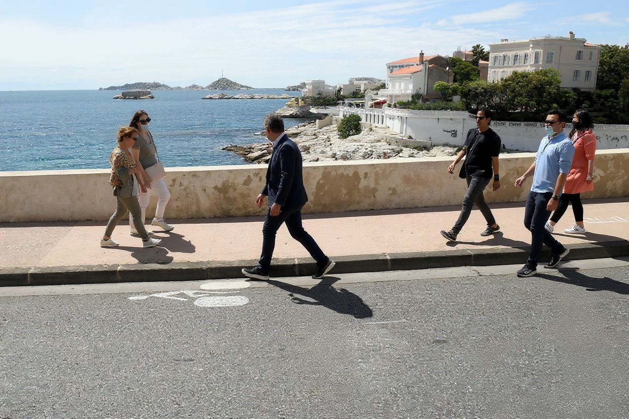 Bystanders stroll on the Corniche road in Marseille, southern France. This road, forbidden to cars for the first time, will be closed one Sunday per month. Source: Nicolas Tucat/