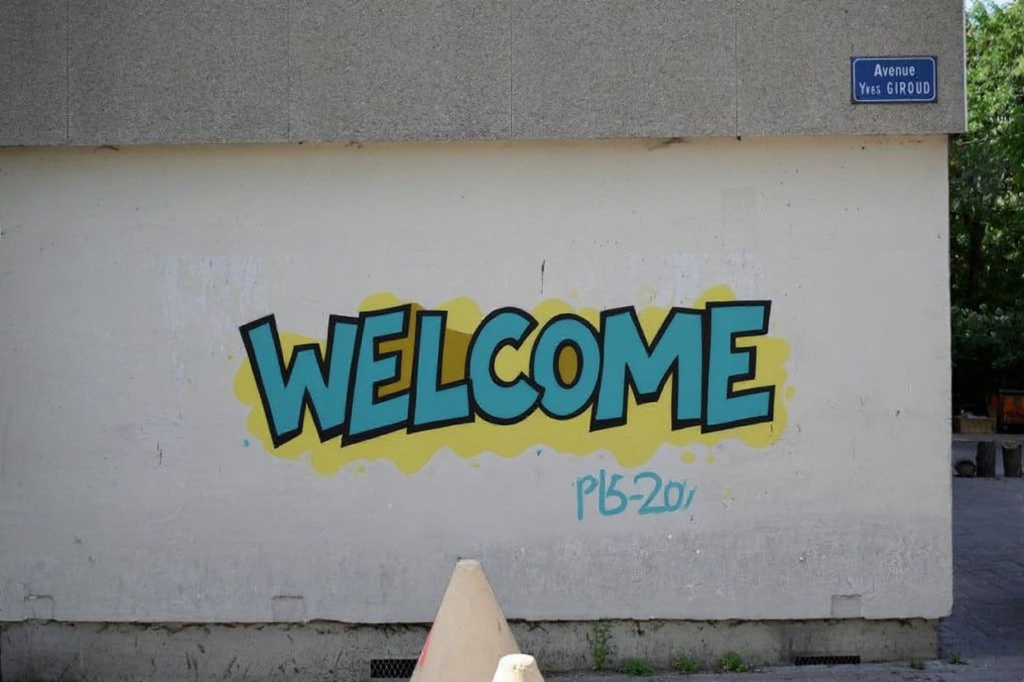 This photograph taken on June 27, 2023, shows a mural writing reading “welcome” and the price of drugs of a dealing point at the Cite de la Castellane housing project in the northern district of Marseille, southern France. (Photo by Nicolas TUCAT / )