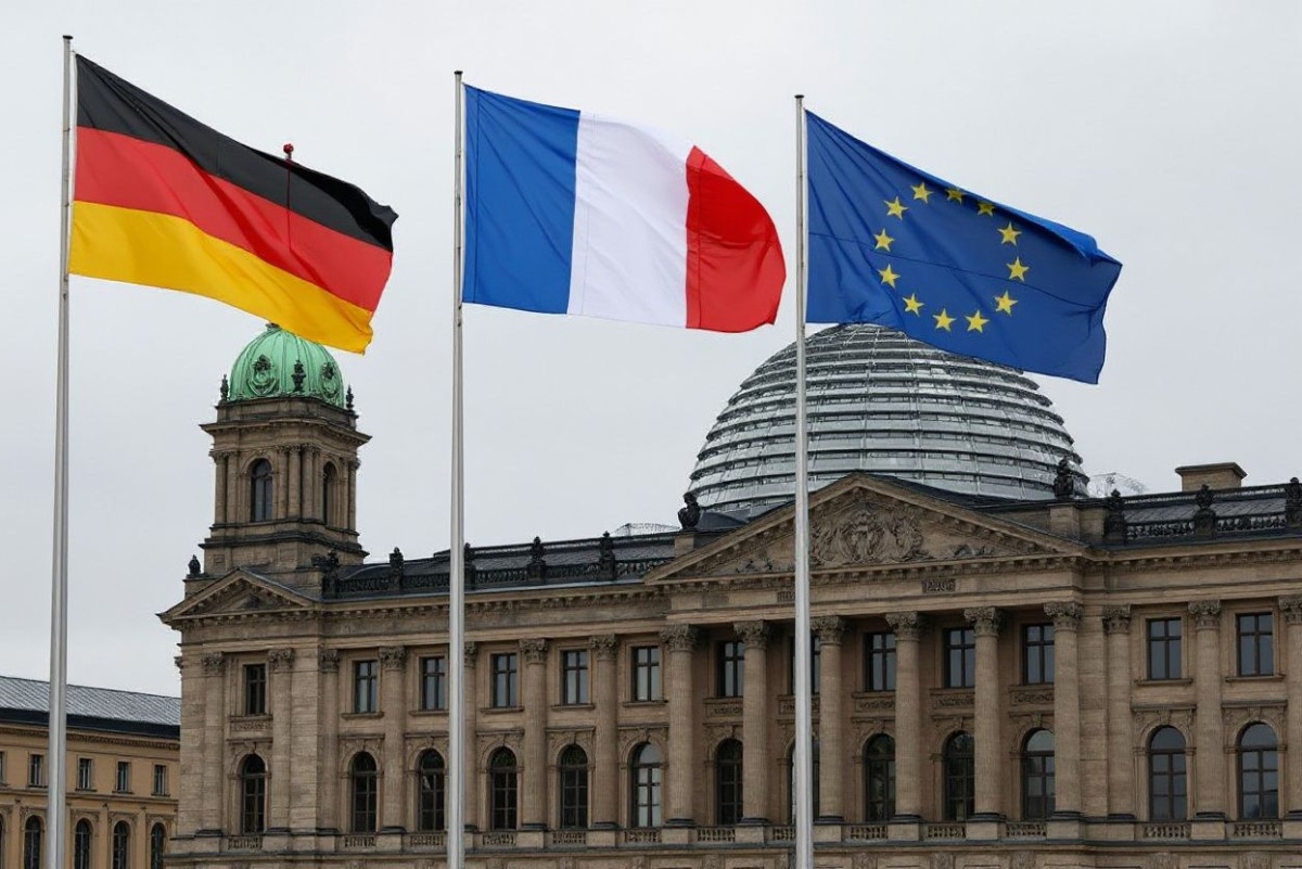 The flags of (L-R) Germany, France and the European Union fly in the wind in front of the Chancellery in Berlin, where the German Chancellor was expected to welcome the French President on October 2, 2024; in background can be seen the cupola of the Reichstag building that houses the Bundestag (lower house of parliament). (Photo by Ludovic MARIN / )