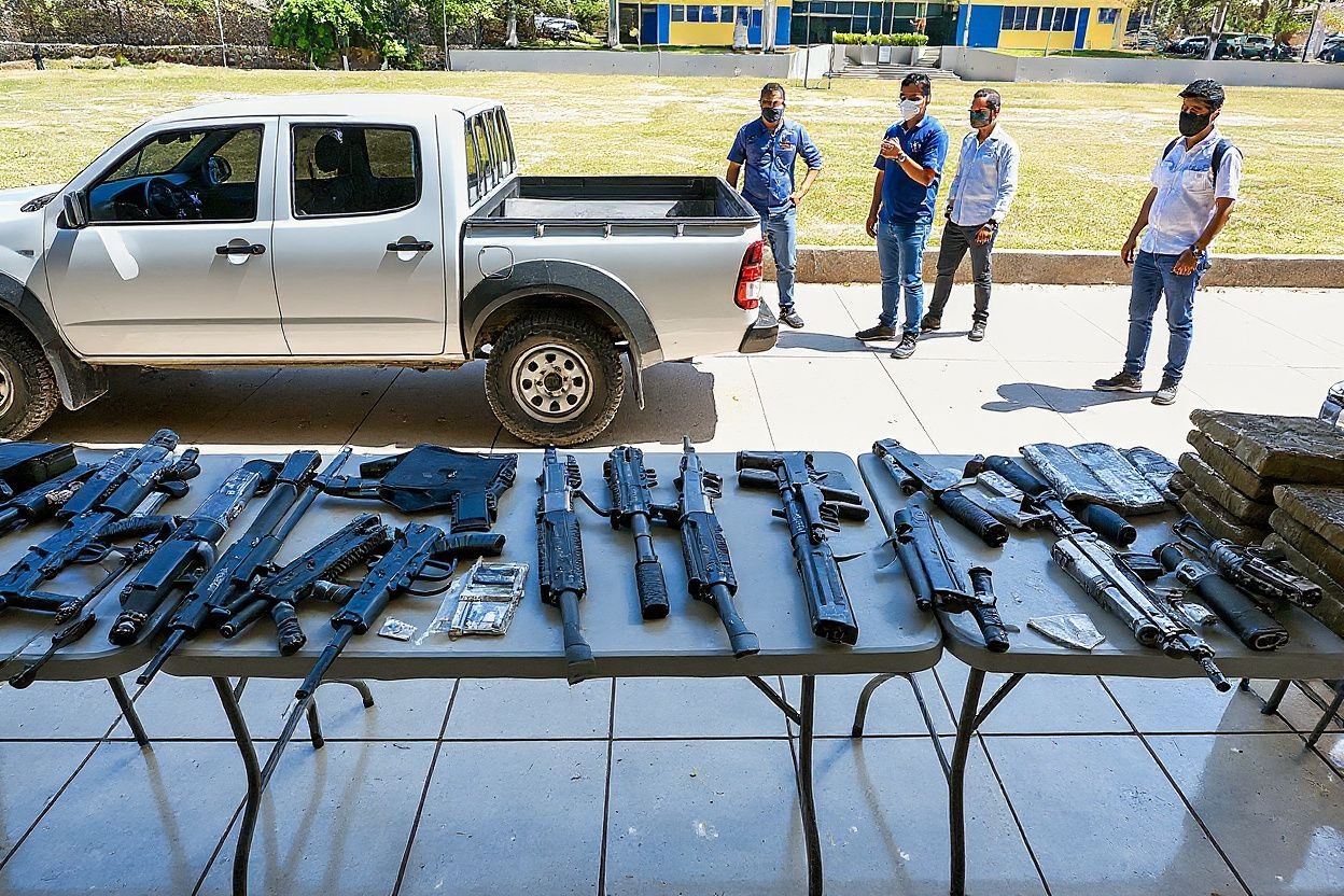 View of weapons and drugs seized from members of the criminal gang Mara Salvatrucha (MS-13) in Tegucigalpa, on February 19, 2021 after the dismantling of an operations centre of the organisation found in the mountains of the department of Olancho, north of Honduras. (Photo by Orlando SIERRA / )