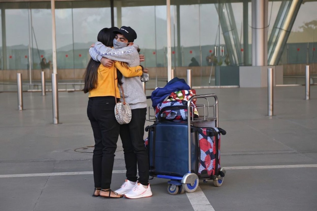 A passenger (L) arriving from the United Kingdom receives a hug by her relative after she went through a Covid-19 coronavirus test at the Sardar Vallabhbhai Patel International Airport in Ahmedabad on December 22, 2020. (Photo by Sam PANTHAKY / )