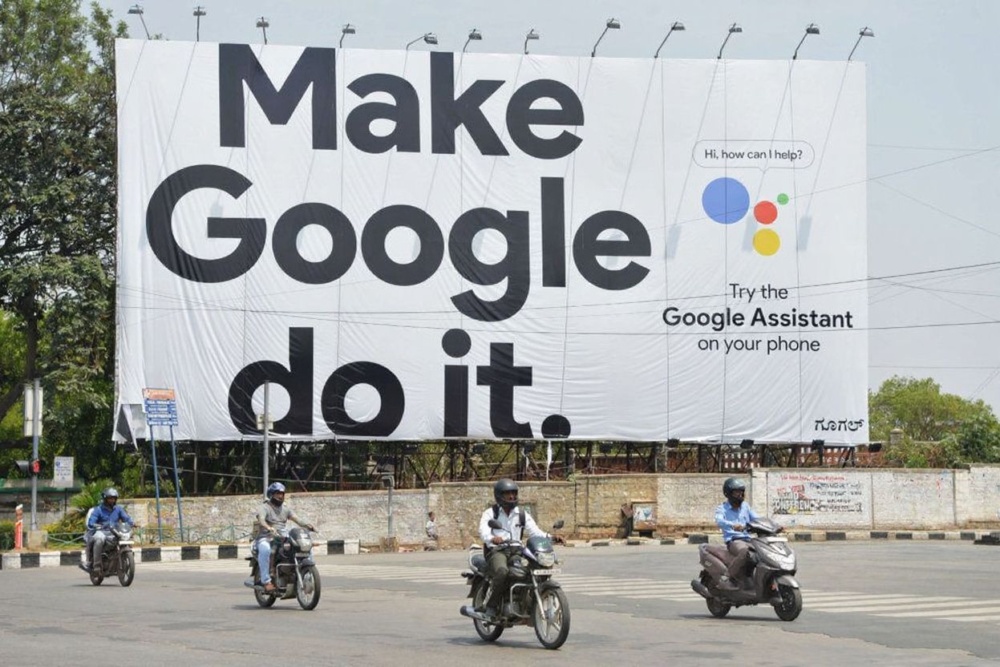 Indian commuters ride past an advertisement poster of Google in Bangalore. Source: Manjunath Kiran/