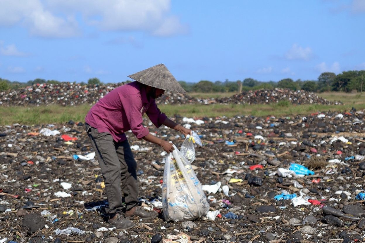 A scavenger collects used plastic items at a landfill in Denpasar on Indonesia’s resort island of Bali on June 9, 2023. (Photo by Sonny TUMBELAKA / )