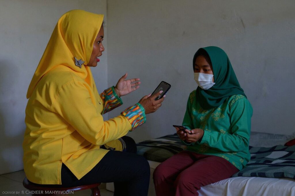 A teacher (L-in yellow) uses sign language to tutor a hearing-impaired student via her smartphone from her home at Pekan Bada, near Banda Aceh on September 14, 2020, as schools remain closed due to the COVID-19 coronavirus pandemic. – Teachers have been tutoring students who lack access to the internet for online classes at their homes following the virus outbreak outbreak. (Photo by CHAIDEER MAHYUDDIN / )