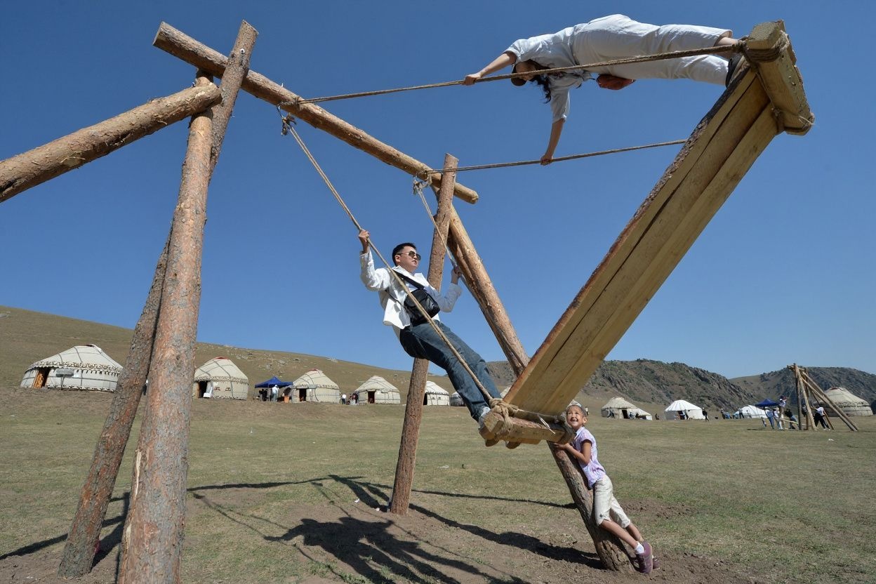 Kyrgyz youth ride a traditional swing. Source: