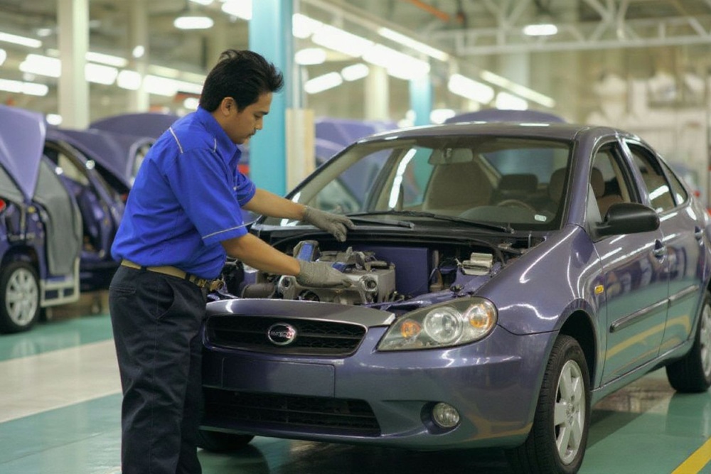 (FILES) In this file picture taken 26 February 2005, an engineer works on a Proton Gen2 car at the new national carmaker Proton plant in Tanjung Malim.  Malaysian national carmaker Proton said 28 June 2005 it plans to export 100,000 units by 2008 and open production plants in China and Russia to minimise the impact of a regional trade pact.   PHOTO/FILES/Jimin LAI (Photo by JIMIN LAI / )