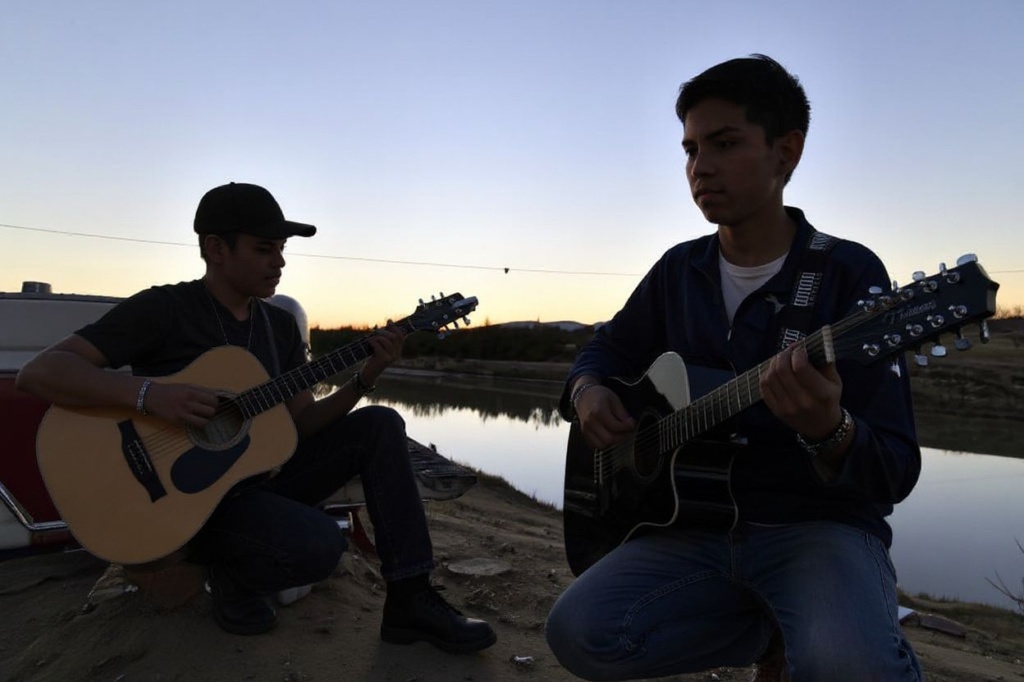 Two Mexican boys play guitars along the bank of Rio Bravo, the natural border between US/Mexico , in Ojinaga, Mexico on February. 20, 2017, north of Mexico. ***Attention Editors, this image is part of an ongoing  photo project documenting the life on the two sides of the US/Mexico border simultaneously by two photographers traveling for ten days from California to Texas on the US side and from Baja California to Tamaulipas on the Mexican side between February 13 and 22, 2017. You can find all the images with the keyword : BORDERPROJECT2017 on our wire and on www.forum.com (Photo by YURI CORTEZ / )