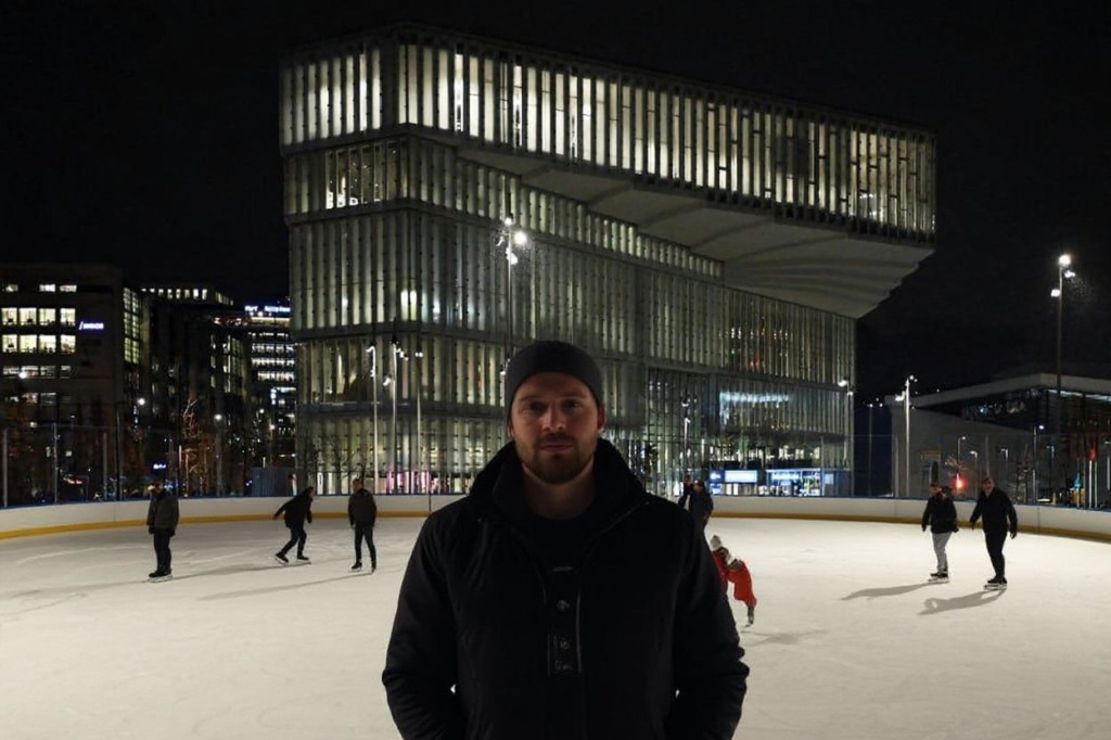 People skate on the ice rink in front of the Deichman Bjorvika central library building downtown Oslo, on December 8, 2022. (Photo by Sergei GAPON / )