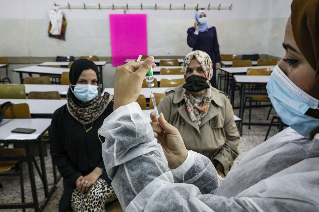 A Palestinian health ministry worker prepares a dose of the Covishield (AstraZeneca) COVID-19 coronavirus vaccine to be administered at a school in the Palestinian city of Hebron.