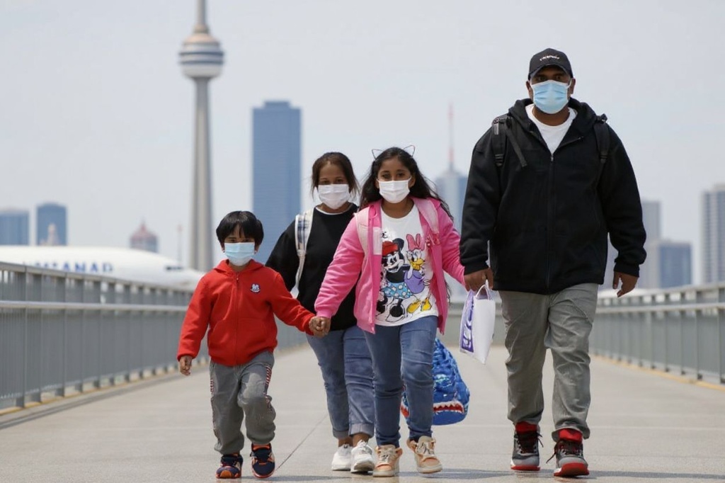 Supun Thilina Kellapatha (R) holds the hand of his daughter Sethumdi (2R) and Nadeeka Dilrukshi Nonis (2L) holds the hand of her son Dinath (L), as they arrive in Canada as refugees at Pearson International Airport in Toronto, Ontario, Canada on September 28, 2021. Canada Tuesday granted asylum to four people who hid former NSA contractor Edward Snowden in their tiny Hong Kong apartments when he was on the run after stealing a trove of classified documents.
The four — Supun Thilina Kellapatha, Nadeeka Dilrukshi Nonis and their children Sethumdi and Dinath — landed in Toronto in the afternoon and were due to go on to Montreal to “start their new lives,” non-profit For the Refugees said in a statement. (Photo by Cole Burston / )