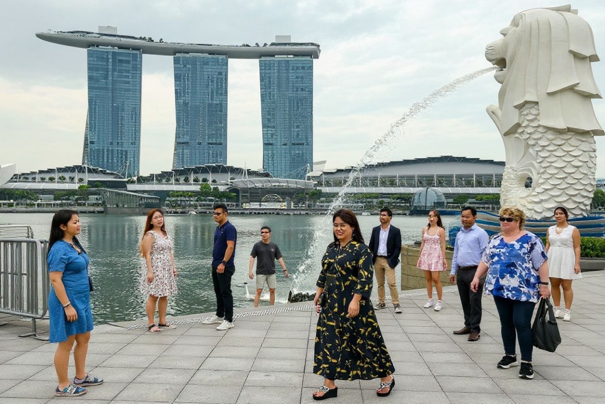 People gather next to the Merlion statue in front of the Marina Bay Sands resort in Singapore on December 2, 2024. (Photo by Roslan RAHMAN and ROSLAN RAHMAN / )