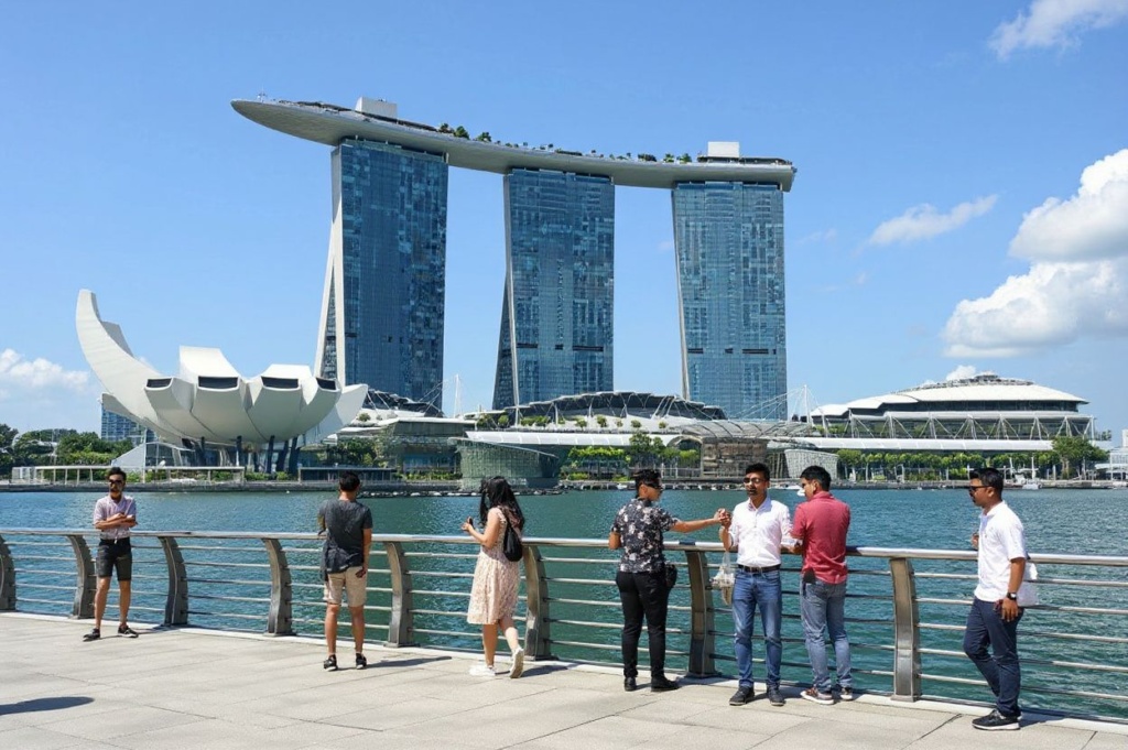 Visitors gather in front of the Marina Bay Sands hotel and resorts building in Singapore on July 27, 2022. (Photo by Roslan RAHMAN / )