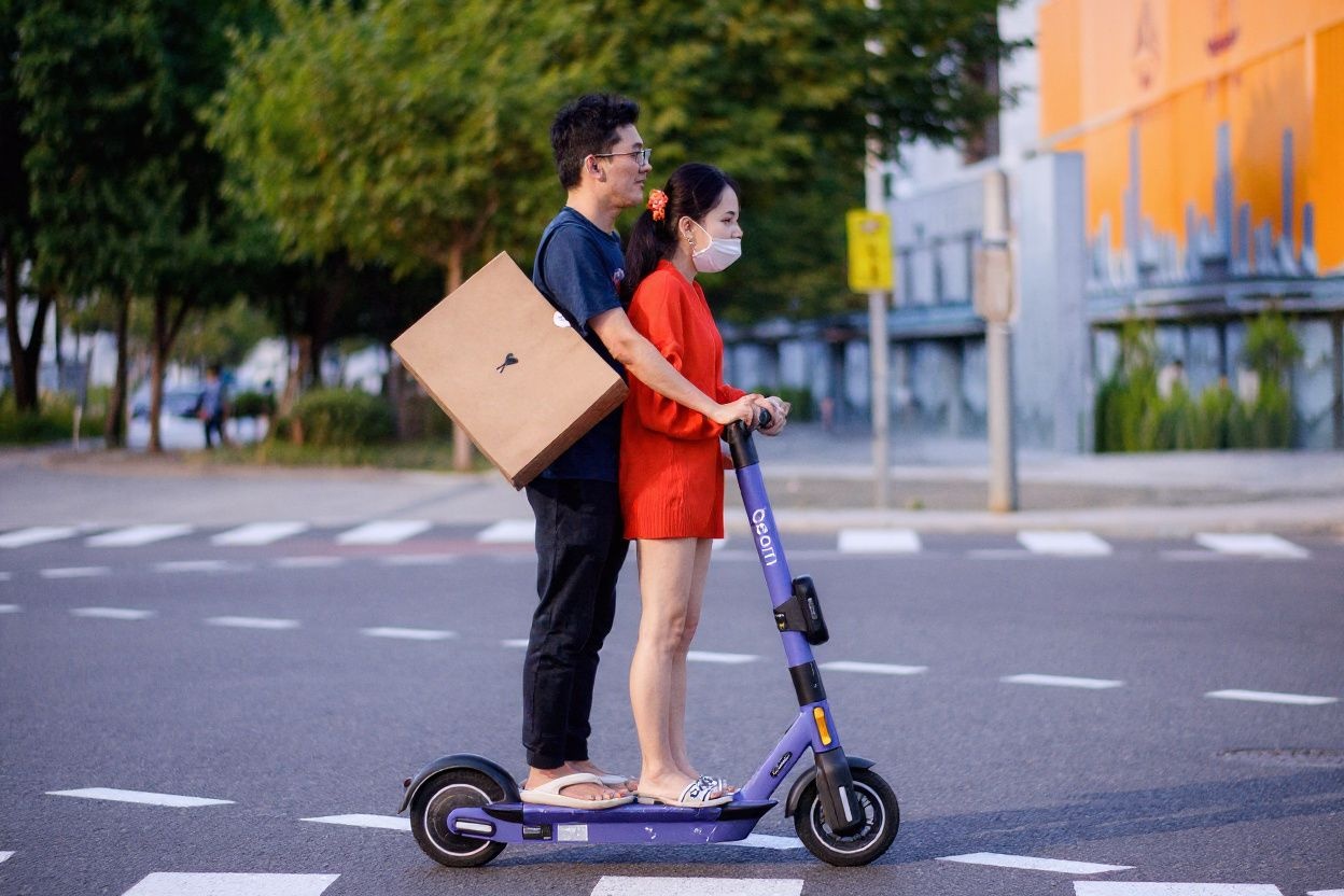 A man and woman ride an electric scooter on a road in Seoul on September 15, 2021. (Photo by Anthony WALLACE / )