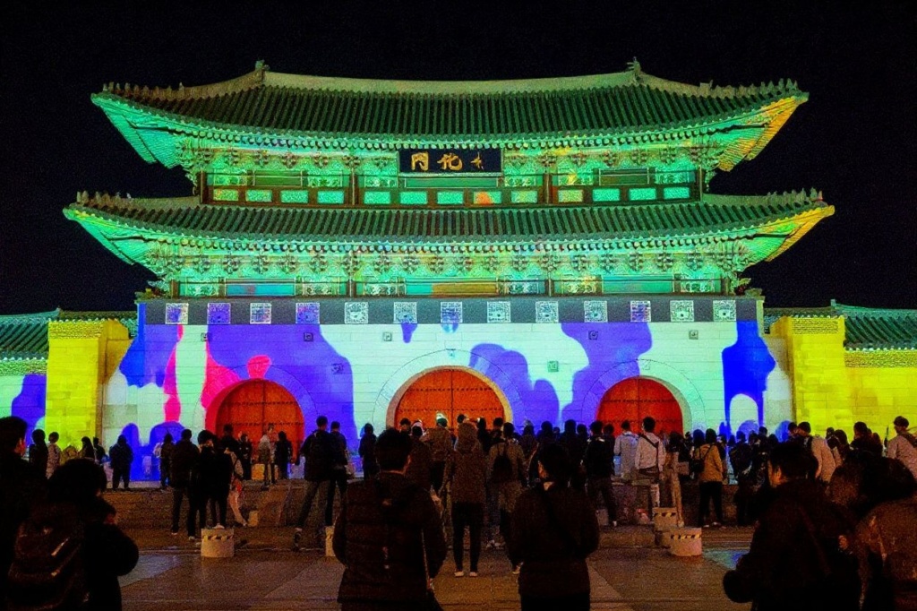 Exchange students watching a light display on the Gwanghwamun Gate of Gyeongbok Palace. Source: