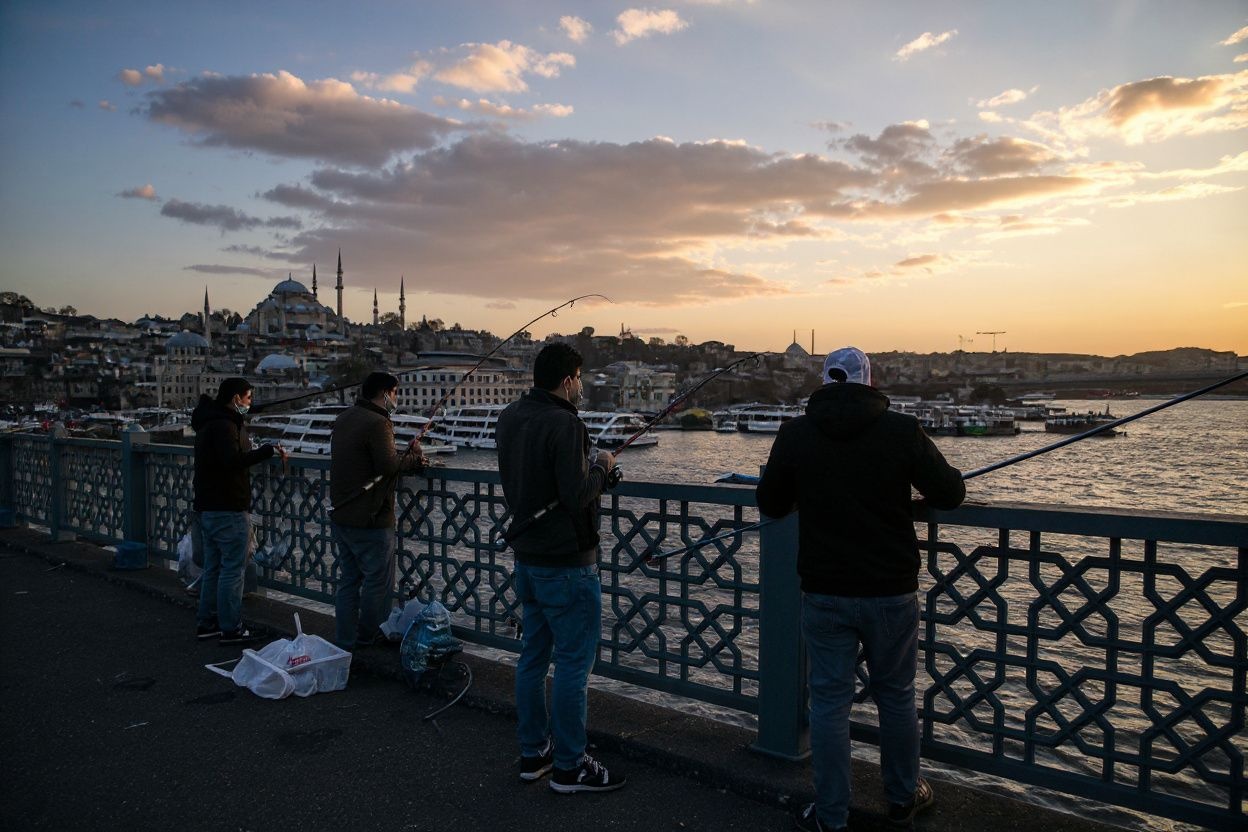 Fishermen stand on the Galata Bridge at sunset at the Eminomu district in Istanbul. Source: Ozan Kose/