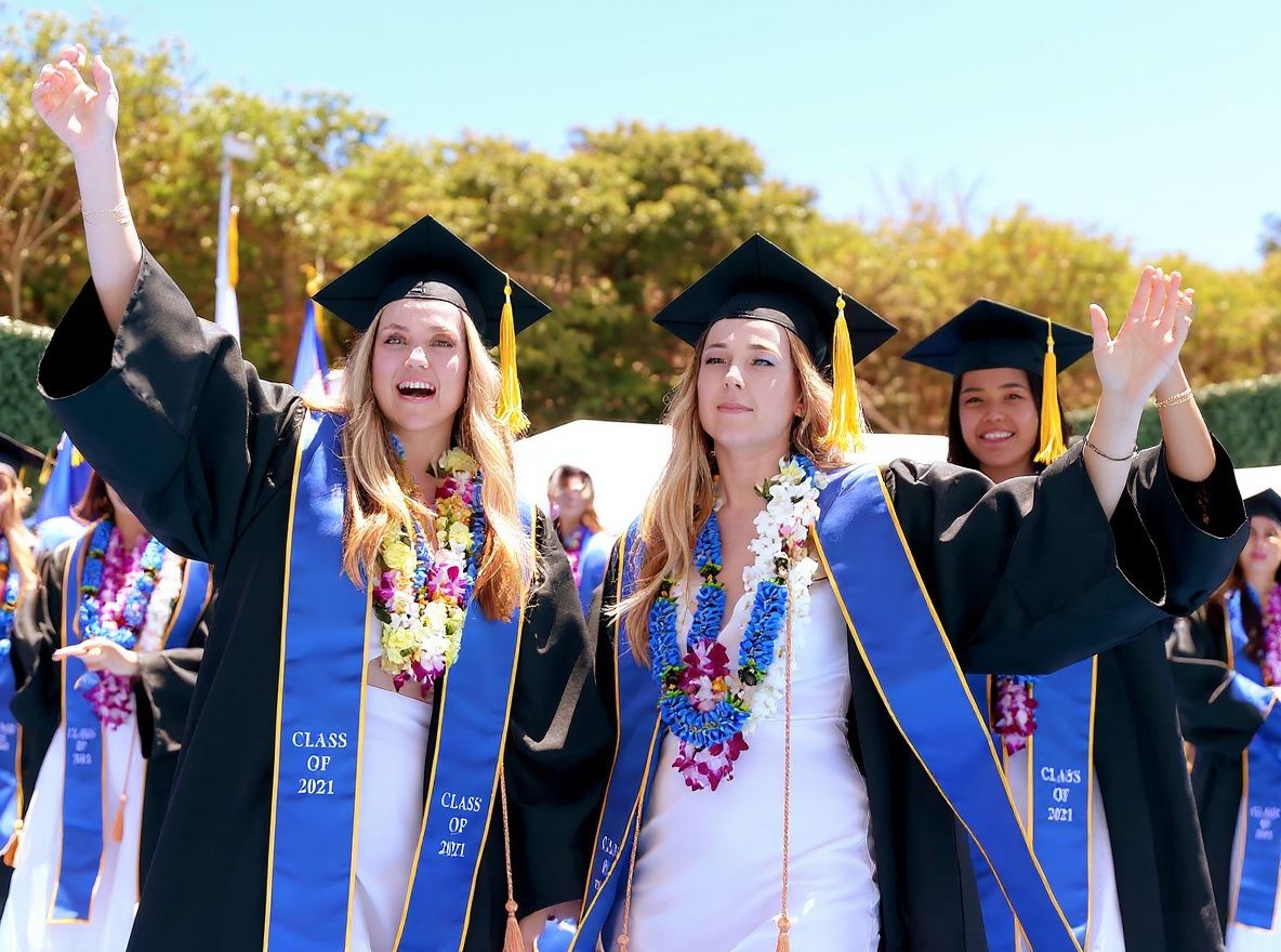 WESTWOOD, CALIFORNIA – JUNE 11: Graduating UCLA students celebrate while walking the stage for their commencement ceremony at Drake Stadium on June 11, 2021 in Westwood, California. Up to 230 students per hour were able to participate in the graduate procession. Each graduate was allowed two guests and were permitted to remove their masks before crossing the stage.   Mario Tama/Getty Images/ (Photo by MARIO TAMA / GETTY IMAGES NORTH AMERICA / Getty Images via )