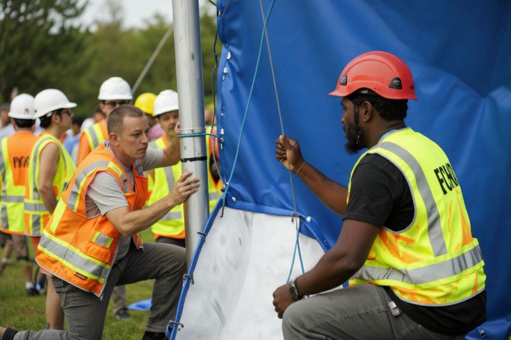 Members of the crew work to secure a side panel into place as they assemble the Big Top ahead of Cirque du Soleil’s upcoming show “Echo” in Tysons Corner, Virginia, on August 27, 2023. ECHO follows a young woman named Future and Dog as they move through a fantasy world exploring the connection, intention, and symbiotic unions between humans and the natural world around them. The show will run in Virginia from September 6 through October 22. (Photo by SAMUEL CORUM / )