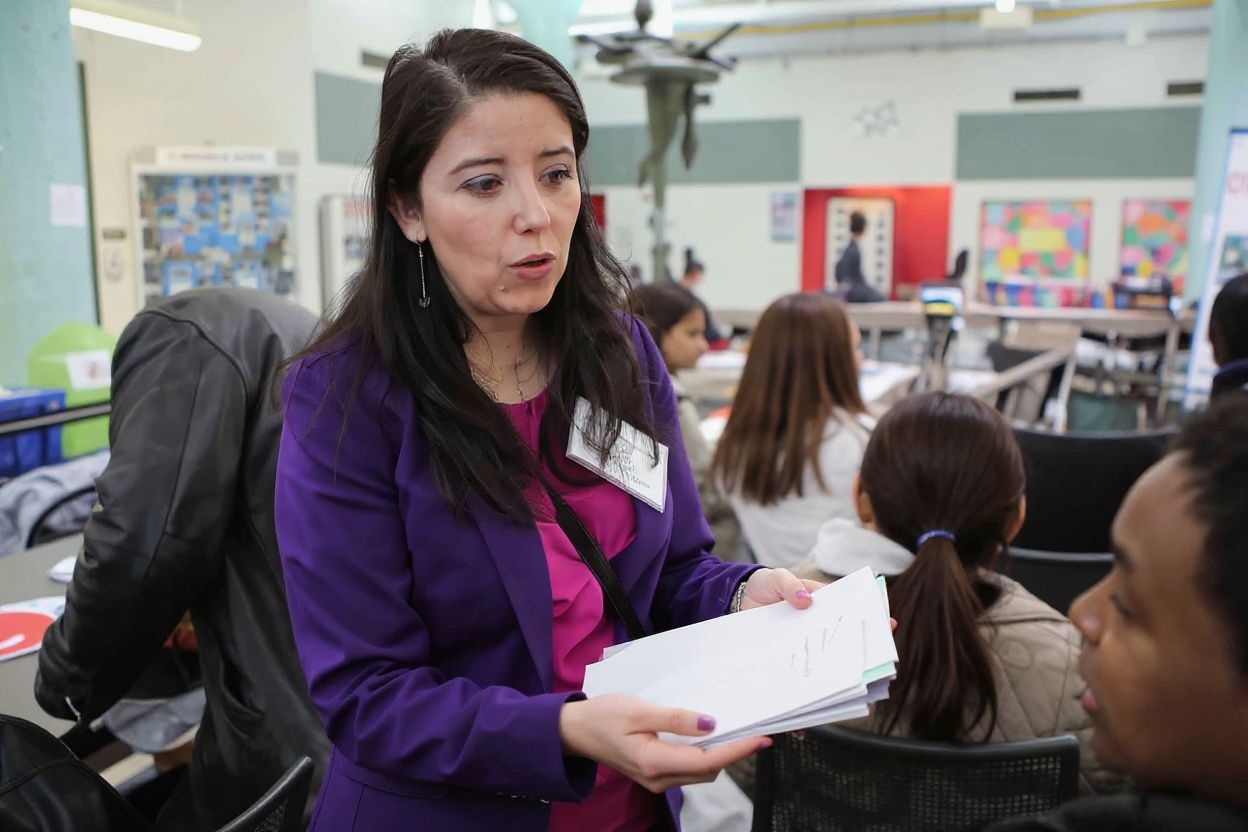 Woman handing out applications. Source: